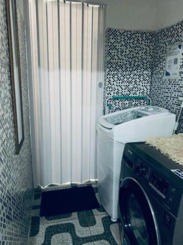 a washing machine in a bathroom with a washer at Casa E-House Manaus in Manaus