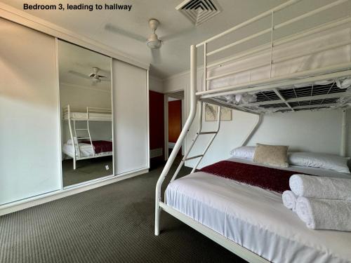 Un dormitorio con una litera y un espejo. en Townsville Apartment on Paxton - First Floor, en Townsville
