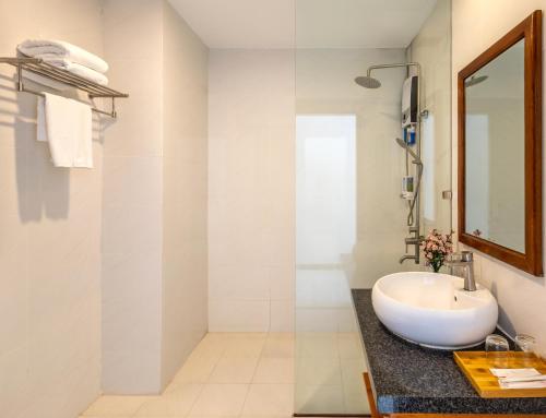 W łazience znajduje się umywalka i lustro. w obiekcie Amon Hotel Phu Quoc w Duong Dong