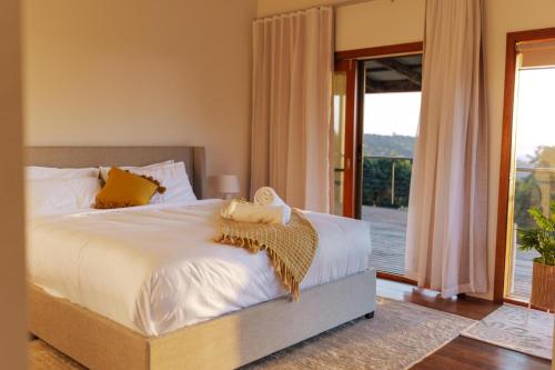 1 dormitorio con 1 cama grande y balcón en Mountain Retreat with ocean views, en Kin Kin