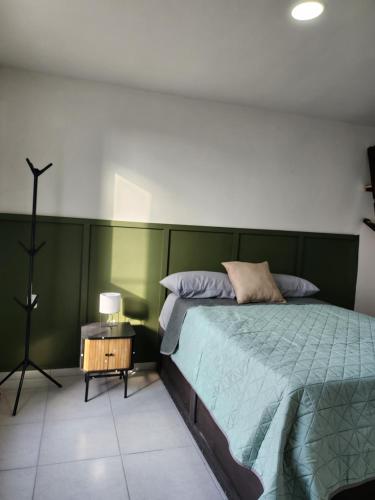 een slaapkamer met een bed met een groen hoofdeinde bij Casa Madero in Ciudad Madero