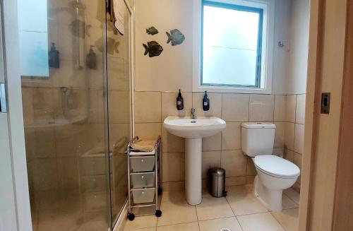 y baño con aseo, lavabo y ducha. en Country Lodge Kinloch, en Taupo