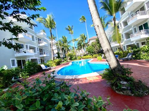 a swimming pool in front of a building at cozy apartment near the beach los corales punta Cana. in Punta Cana