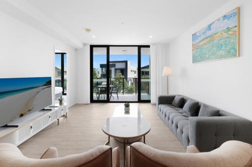 a living room with a couch and a tv at The Residences at The Peninsula in Gold Coast