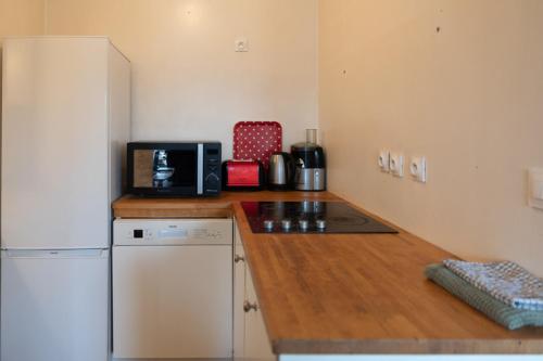 a kitchen with a white refrigerator and a microwave at Luminous cocoon - view of Canal Saint-Martin in Paris