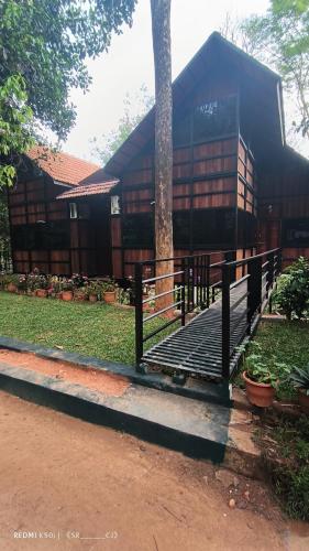 a building with a tree in front of it at Tree House Wayanad in Muthanga