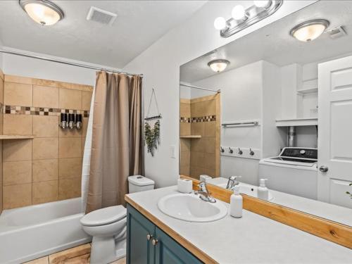 a bathroom with a sink and a toilet and a mirror at Heber Apartment Hideaway in Heber City