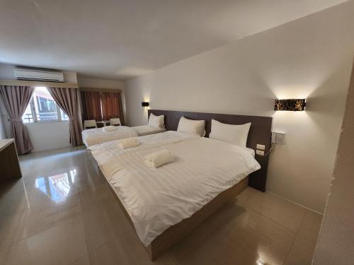 Prom Ratchada Hotel - SHA Plus في بانكوك: غرفة نوم كبيرة بسريرين مع شراشف بيضاء