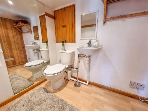 a bathroom with two toilets and a sink at City SuperHost - Peaceful Home in Salford in Manchester