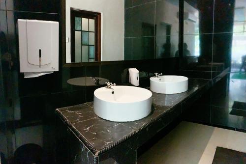 a bathroom with two sinks on a black counter at OS Hotel Batu Aji Batam in Batam Center
