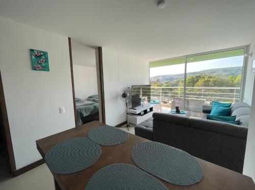 a living room with a table and a large window at Espectacular apartamento en Melgar in Melgar