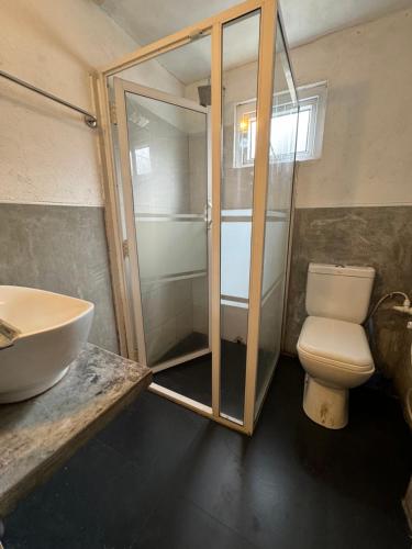 a bathroom with a shower and a toilet and a sink at Natures Bliss Holidays in Ja-Ela