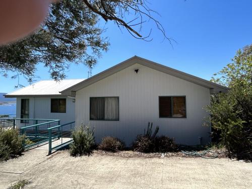 a white house with a driveway in front of it at Naturescape in Jindabyne