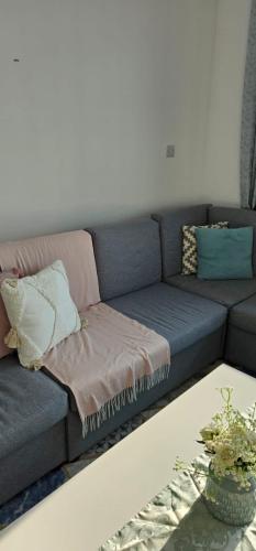 un sofá azul con almohadas en la sala de estar en Ajman Cornish Residence, en Ajman