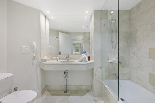 a bathroom with a sink and a shower and a toilet at Ocean View 2-Bed Studio In the Heart of Surfers in Gold Coast