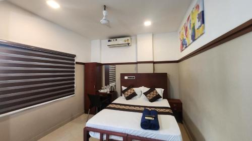 a small room with a bed and a desk at RAINBOW ROOMS in Kozhikode