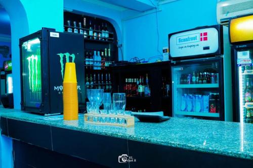 a bar with a counter with glasses and a drink cooler at FORTUNE PEARL HOTEL in Lagos