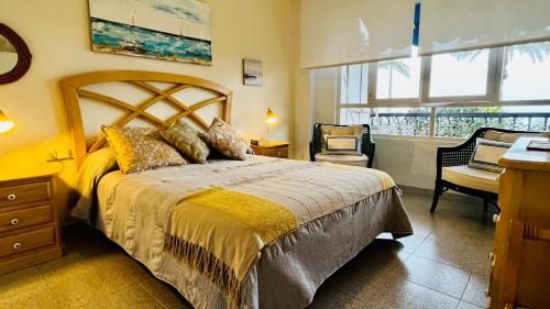 a bedroom with a bed and a desk and a window at Brisas del Mar Mediterráneo in Aguadulce