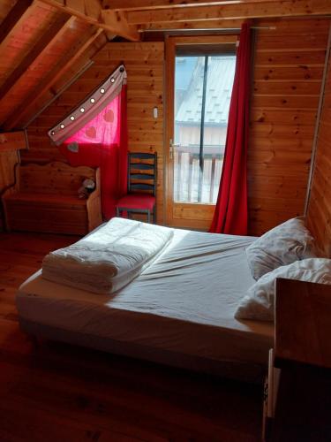 een bed in een houten kamer met een raam bij Marmotte 2 in Ornon