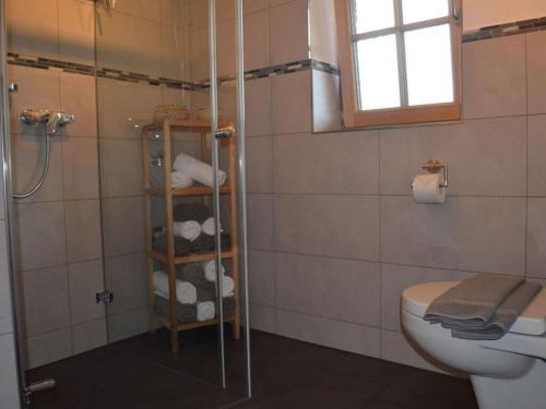 uma casa de banho com chuveiro, WC e toalhas em Lovely apartment in Gaißach em Gaißach