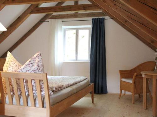 um quarto com uma cama, uma janela e uma cadeira em Pleasant apartment in Diessen 