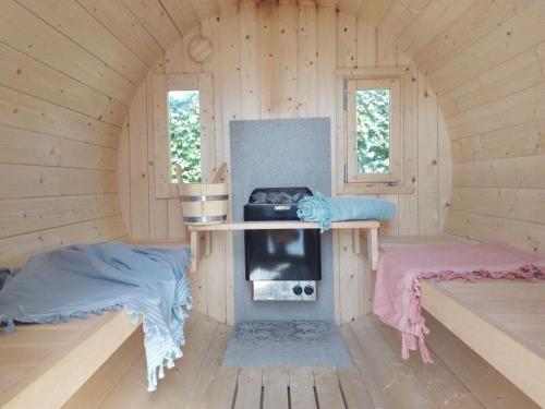 a room with a fireplace in a wooden cabin at Holiday home Zanddrijver in Makkum