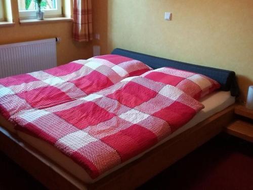 - un lit avec une couverture rouge et blanche en damier dans l'établissement Lovely apartment in Reken, à Reken