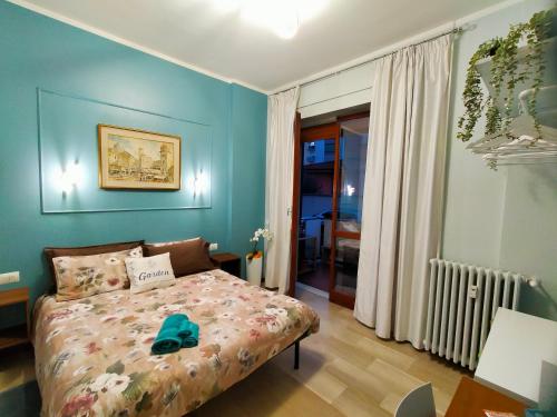 een slaapkamer met een bed en een blauwe muur bij GARDEN in Milaan