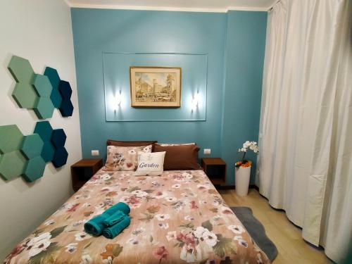 een slaapkamer met een bed in een kamer met blauwe muren bij GARDEN in Milaan