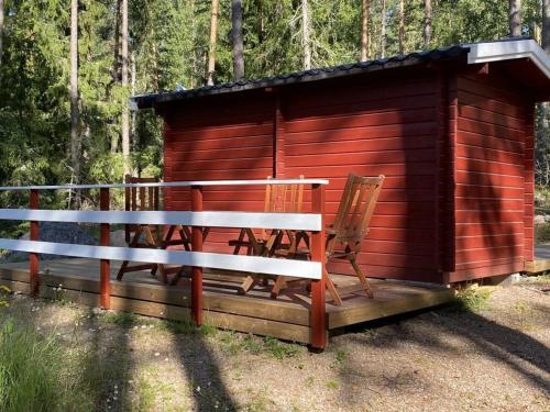 a wooden cabin with two chairs in front of it at Modern apartment in Vimmerby in Vimmerby