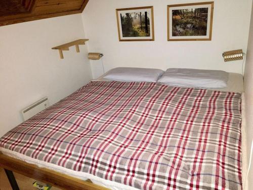ein Bett in einem Schlafzimmer mit einer karierten Decke darauf in der Unterkunft Modern apartment in Vimmerby in Vimmerby