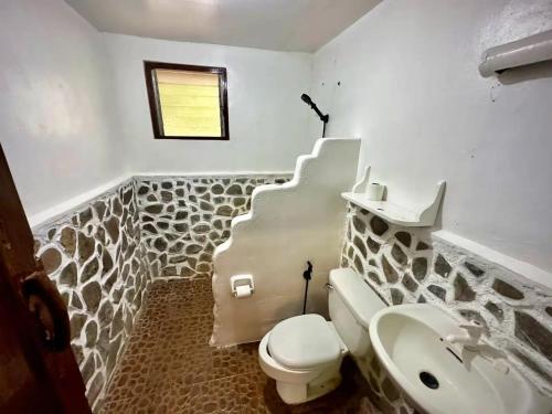 a bathroom with a toilet and a sink at Playa del Fuego Camiguin Beach Hostel & Resort in Mambajao