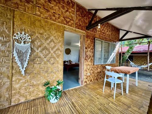 a patio with a table and chairs on a brick wall at Playa del Fuego Camiguin Beach Hostel & Resort in Mambajao