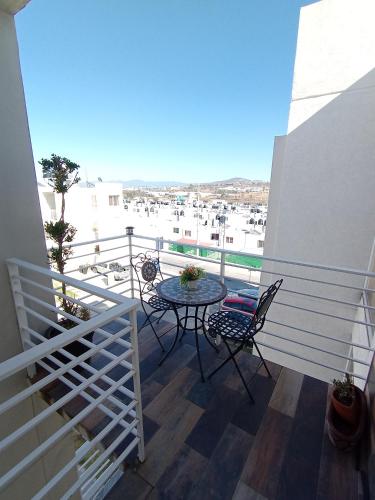balcón con mesa y sillas y vistas al puerto en Encanto, en Atapaneo