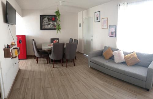 uma sala de estar com um sofá e uma mesa com cadeiras em Encanto em Atapaneo