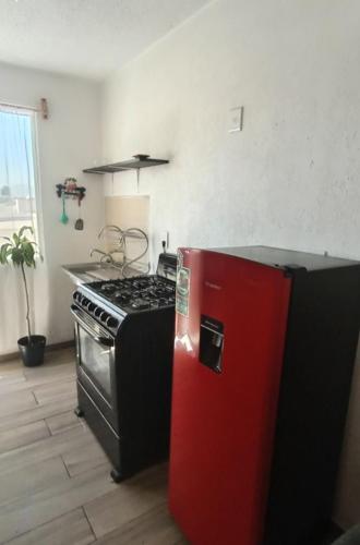 a kitchen with a stove and a red refrigerator at Encanto in Atapaneo