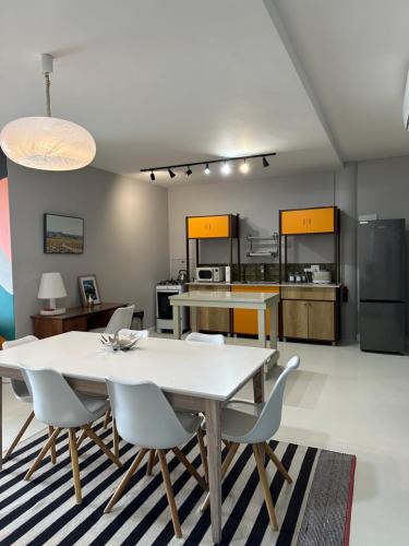 een eetkamer met een tafel en stoelen en een keuken bij Constantia View Apartments OPERATIONAL DURING LOADSHEDDING in Kaapstad