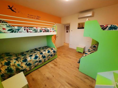 een slaapkamer met 2 stapelbedden en een groene trap bij New Bedrooms Mamma Gigetta in Noventa di Piave