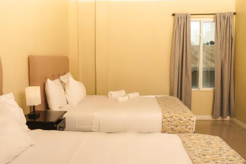 um quarto de hotel com duas camas e uma janela em Parc Rayne em Georgetown