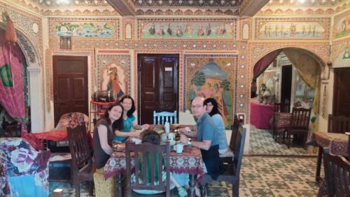 a group of people sitting at a table in a room at Hotel Shekhawati Haveli in Mandāwa