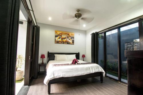 um quarto com uma cama e um quadro na parede em Villa cinta buana 1 em Legian