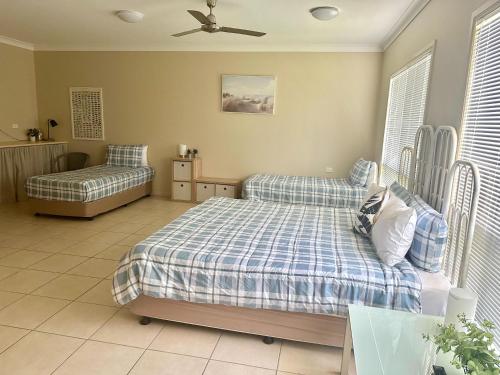 ein Schlafzimmer mit einem Bett, einem Sofa und einem Ventilator in der Unterkunft Hinchinbrook Resorts Management Pty Ltd in Lucinda