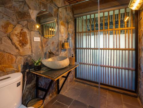 a stone bathroom with a sink and a toilet at Sapaxa Spring Garden Ecolodge in Sa Pa