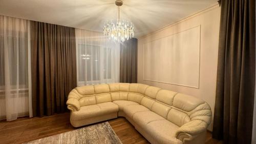 a living room with a couch and a chandelier at Nurtau in Pavlodar
