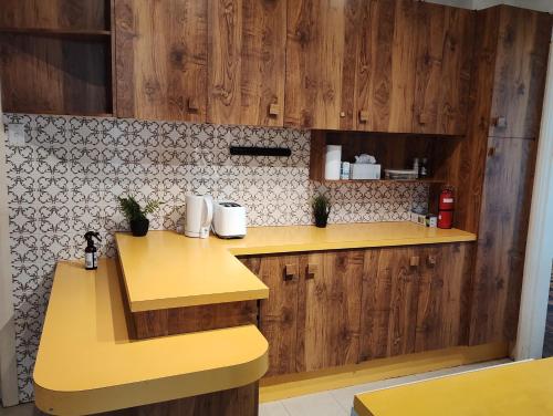 a kitchen with a yellow counter and wooden cabinets at Private separate unit - A in O'Connor in Canberra