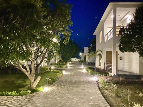 una calle por la noche con un árbol y un edificio en The White Oak Corbett Spa & Resort en Rāmnagar