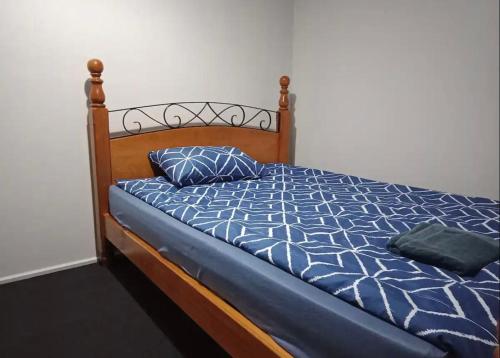 Bett mit blauer Bettdecke und 2 Kissen in der Unterkunft Peaceful cozy home in Kennington