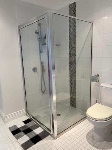 een douchecabine in een badkamer met een toilet bij Violet Cottage in the City in Hobart