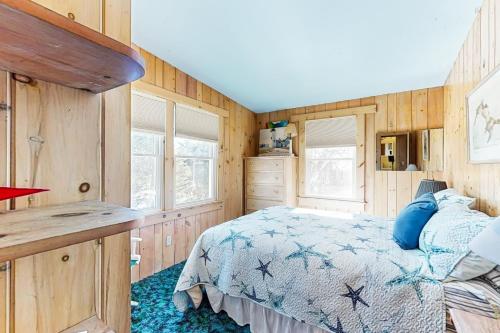 a bedroom with a bed and wooden walls at Gramse Cape House in Barnstable
