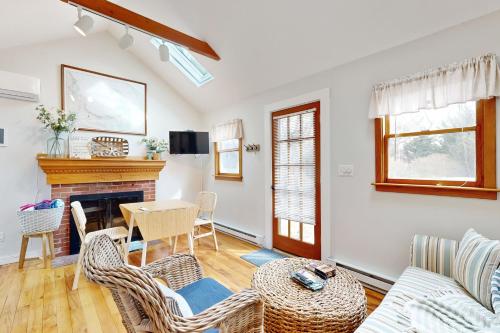 a living room with a table and chairs and a fireplace at Cozy Escape on the Cape in Eastham
